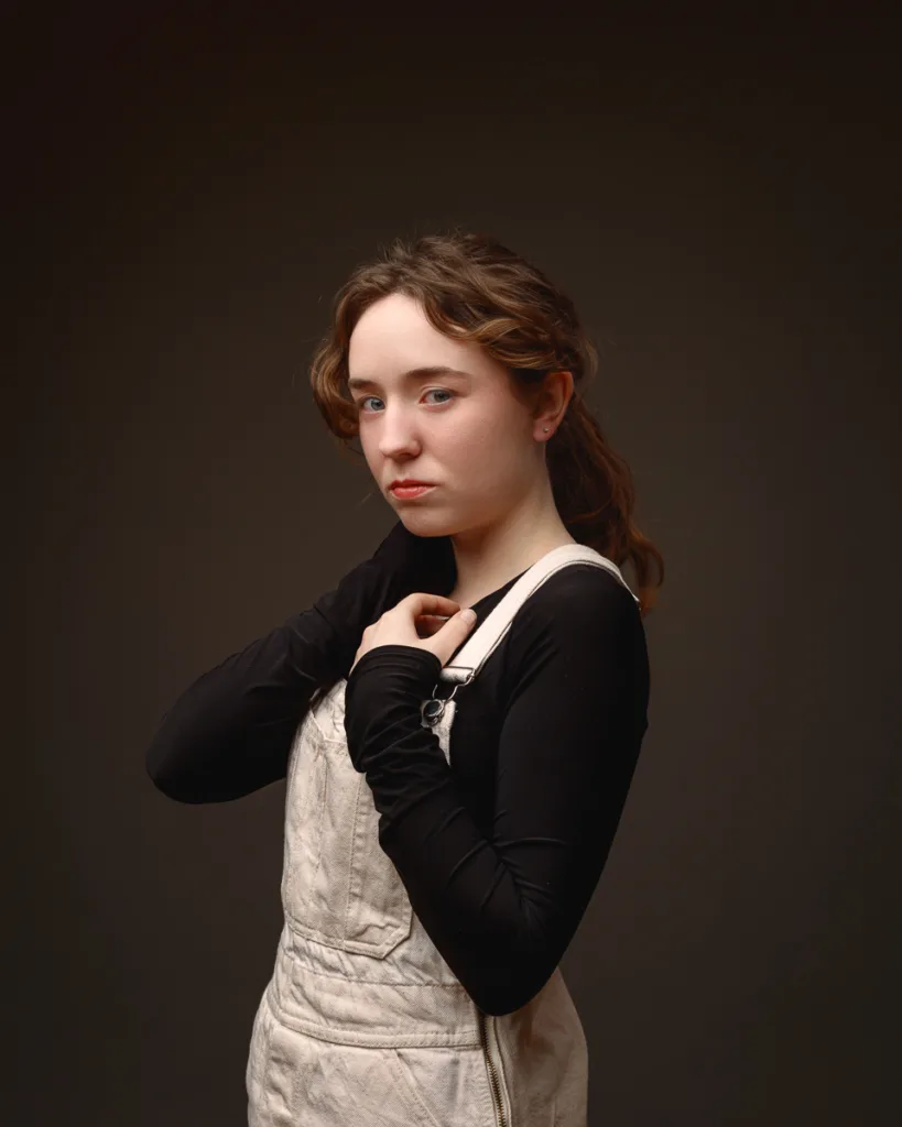 Young woman posing in studio wearing dungarees