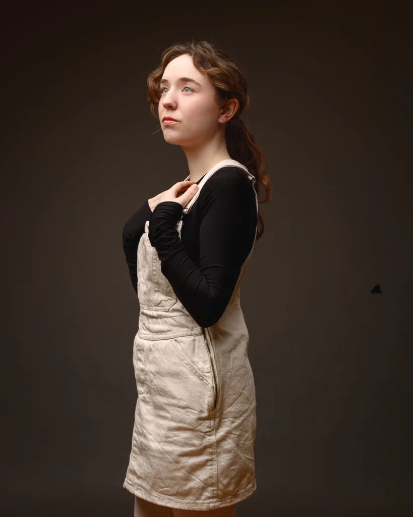 Person posing in beige dress and black top