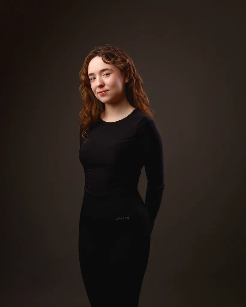 Woman posing confidently in dark studio portrait