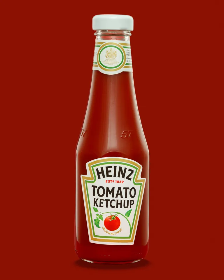 Product photograph of a bottle of Heinz tomato ketchup on a red background