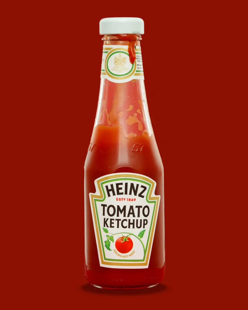 Heinz tomato ketchup glass bottle on red background