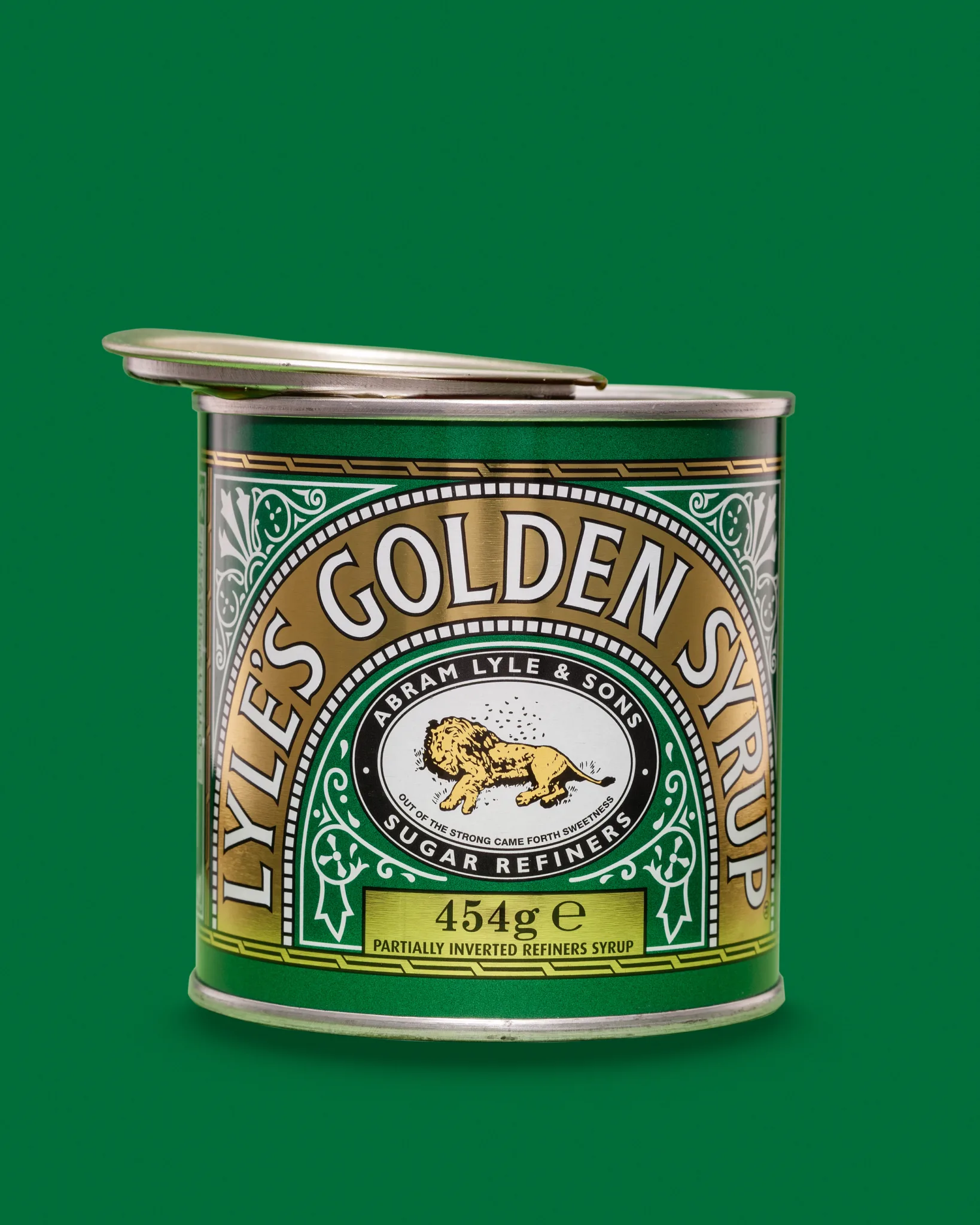 Tin of Lyle's Golden Syrup on green background