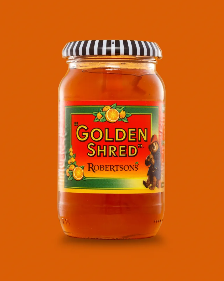Product photograph of a jar of Robertson's Golden Shred marmalade on an orange background