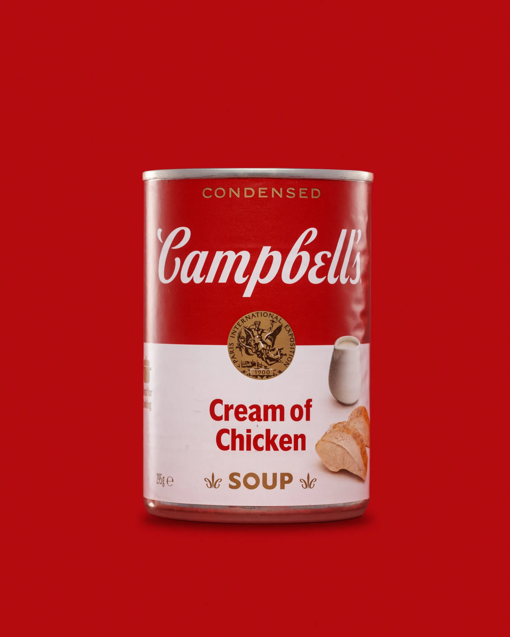 Campbell’s cream of chicken soup can on red background