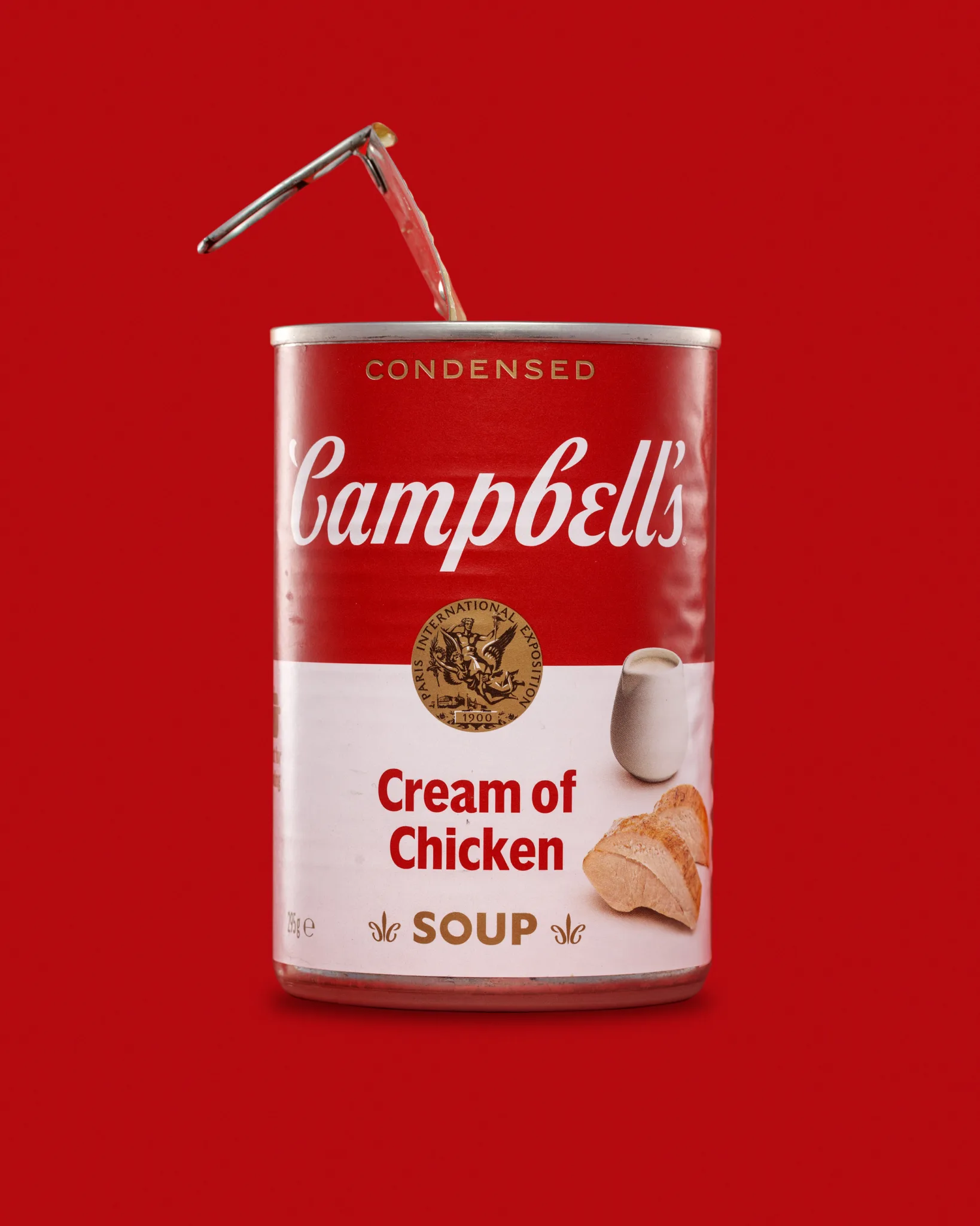 Campbell’s Cream of Chicken Soup tin on red background