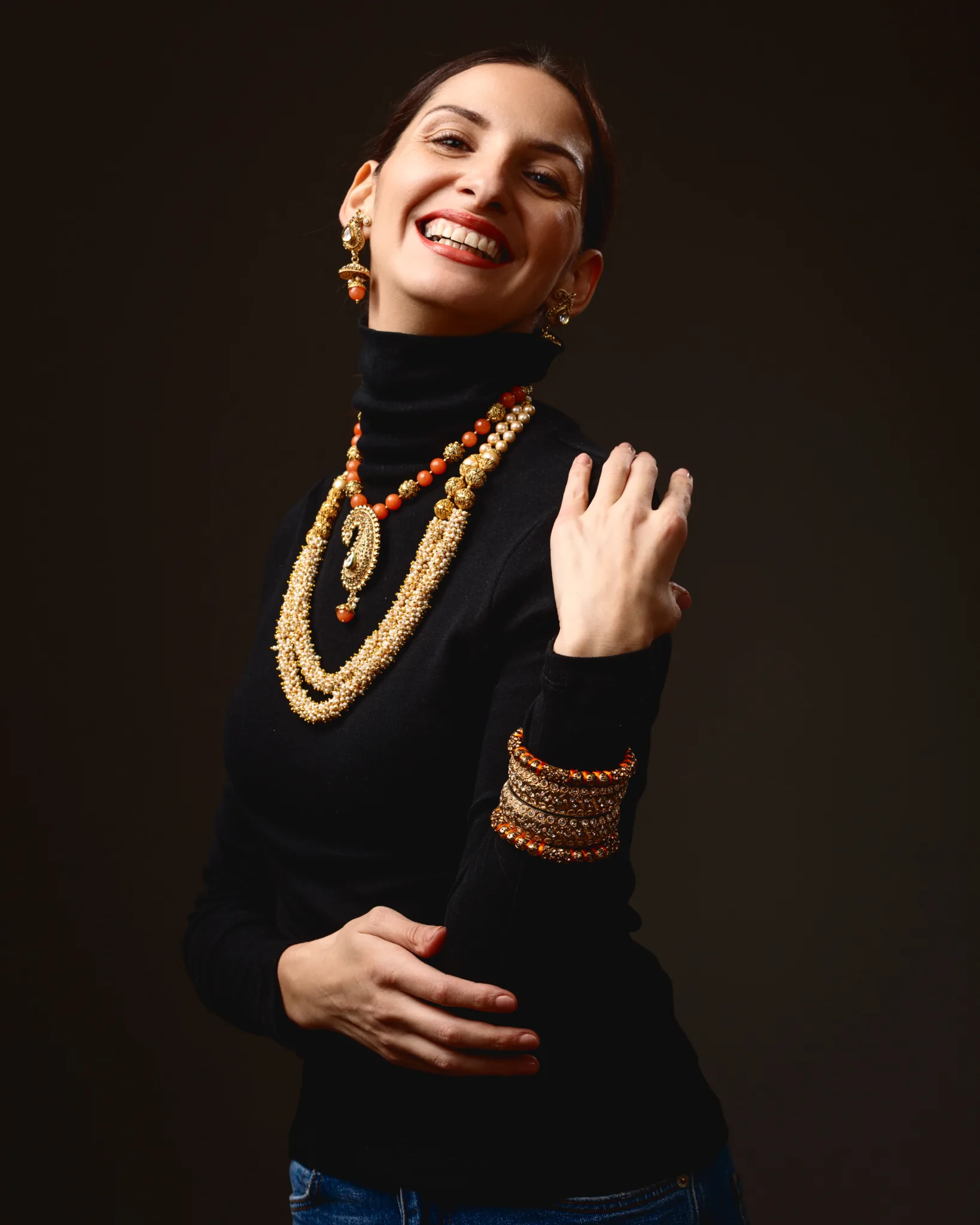 Smiling woman wearing ornate jewellery and bracelet.