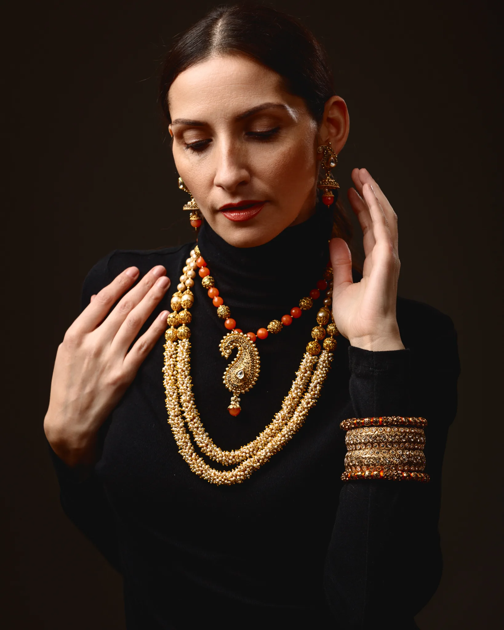 Woman wearing traditional gold and red jewellery set.