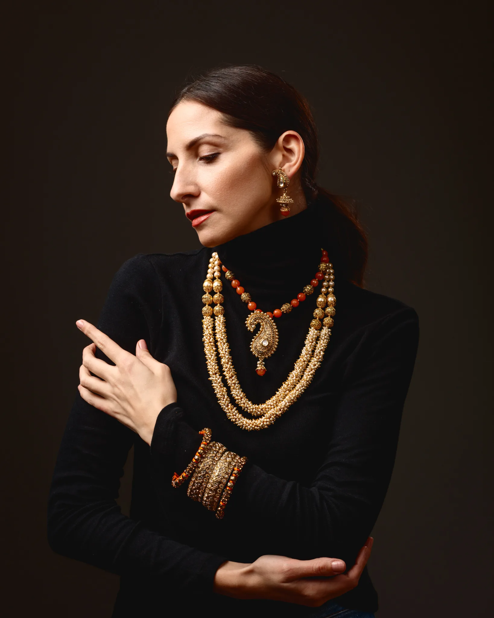 Woman in black with gold jewellery.