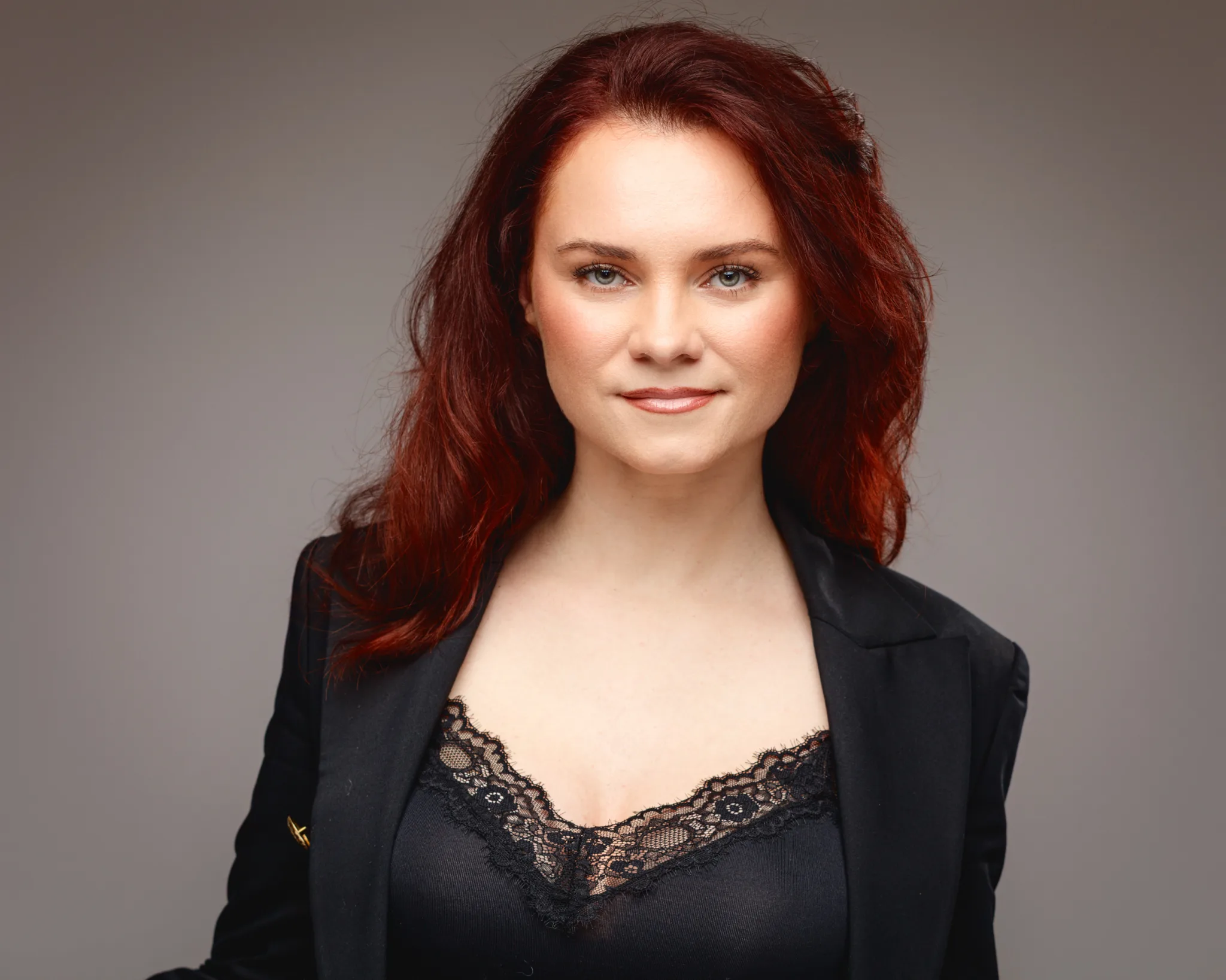Woman with red hair in black lace top.