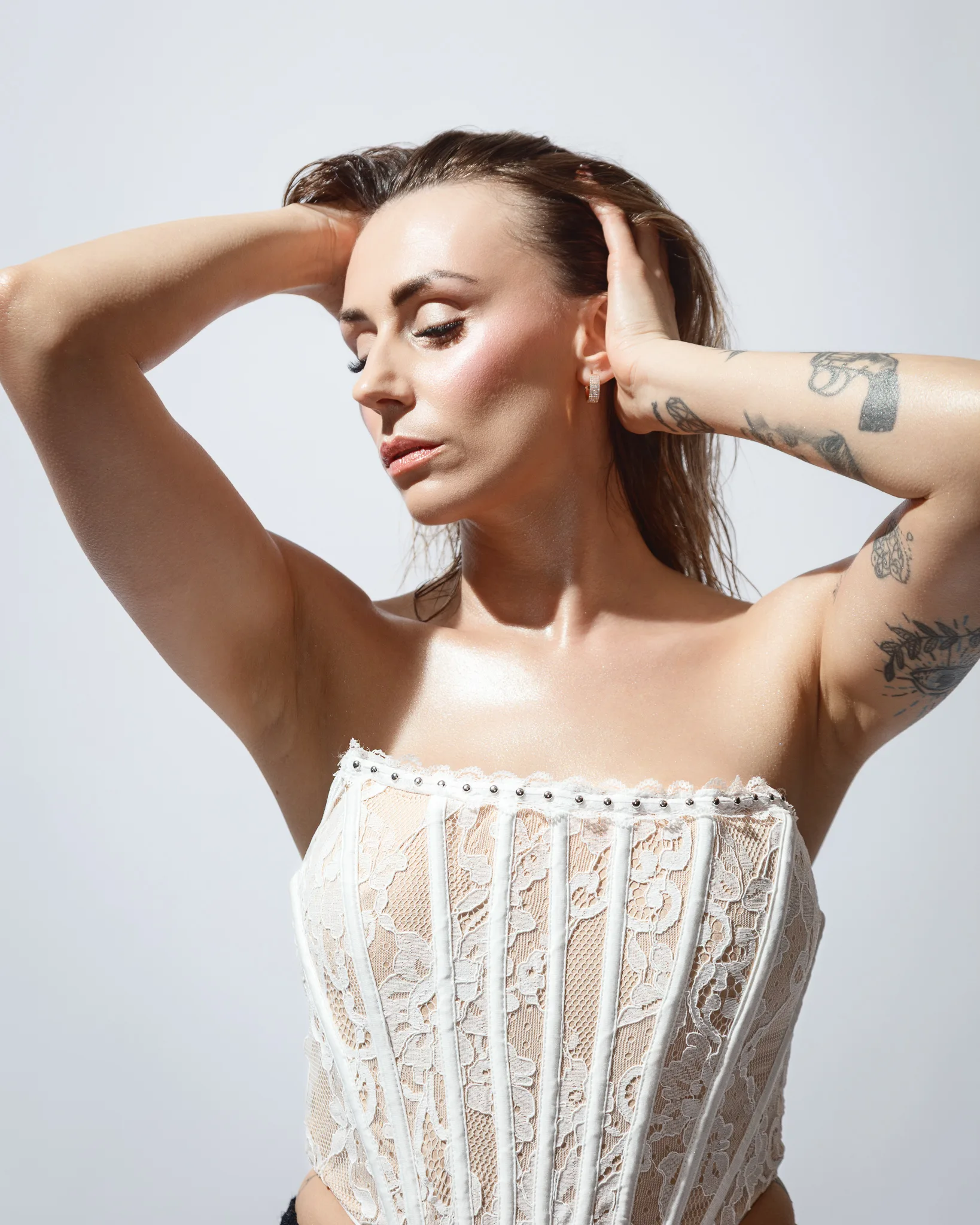 Woman with tattoos wearing a lace corset.