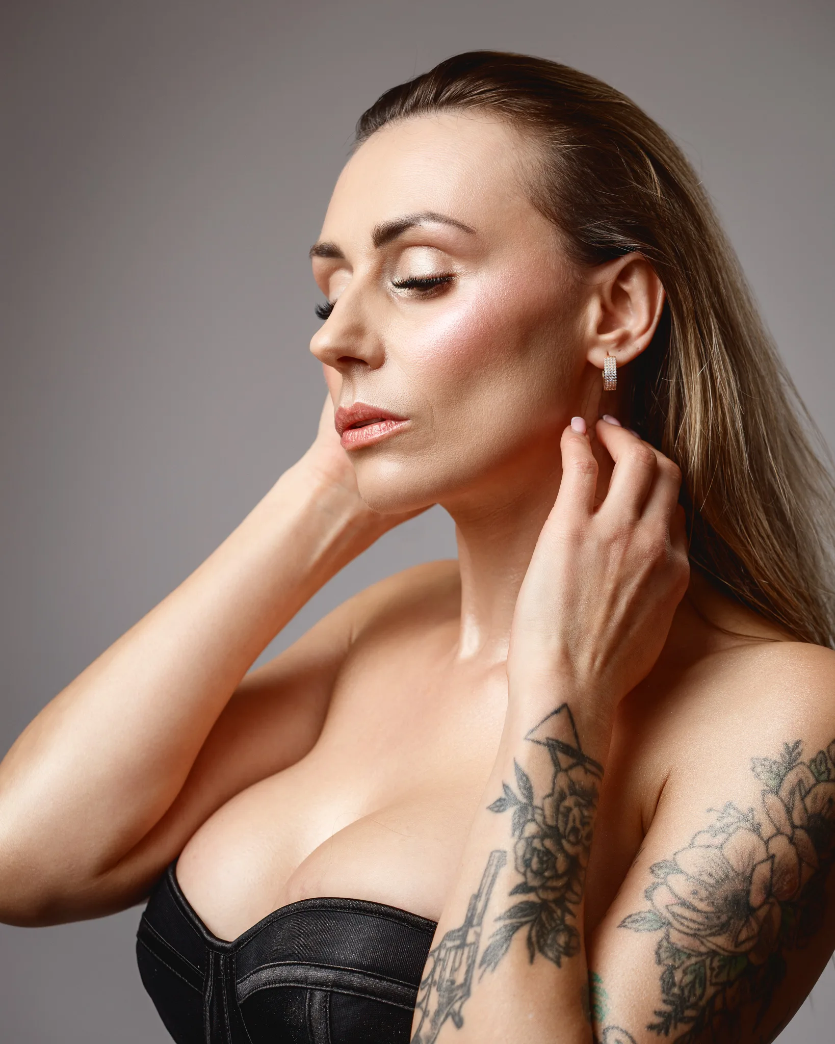 Woman with tattoos posing in black top