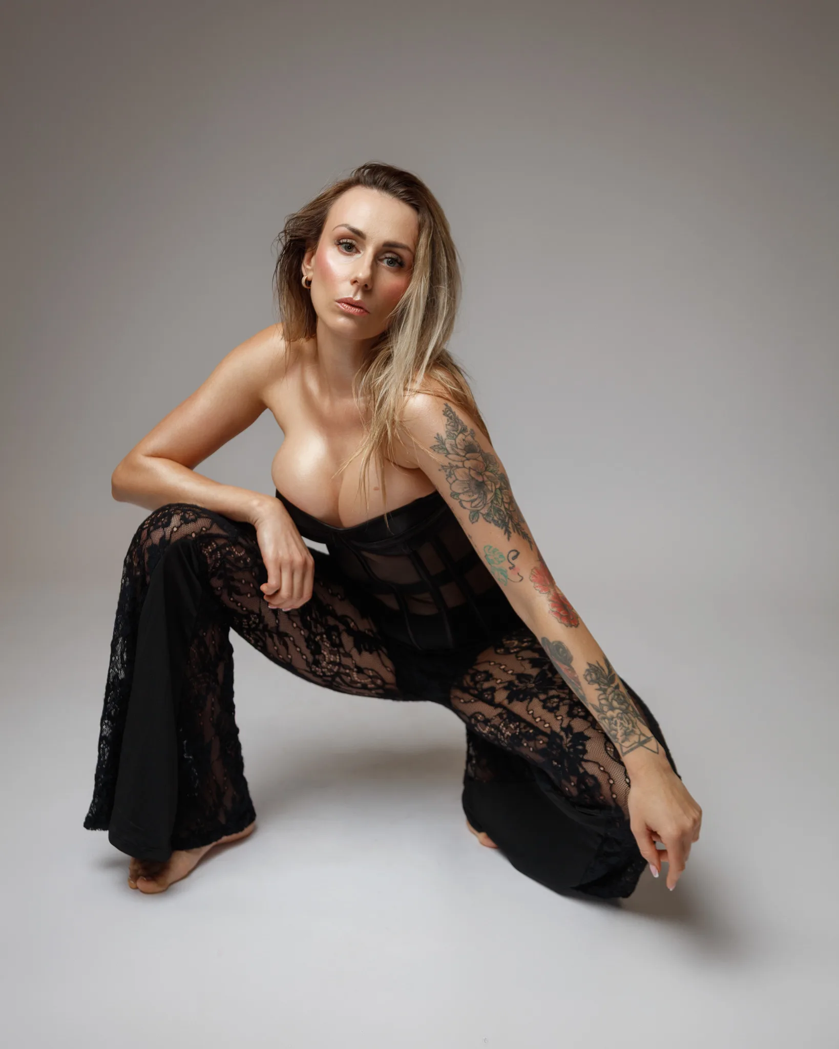 Woman posing in black lace corset and trousers.