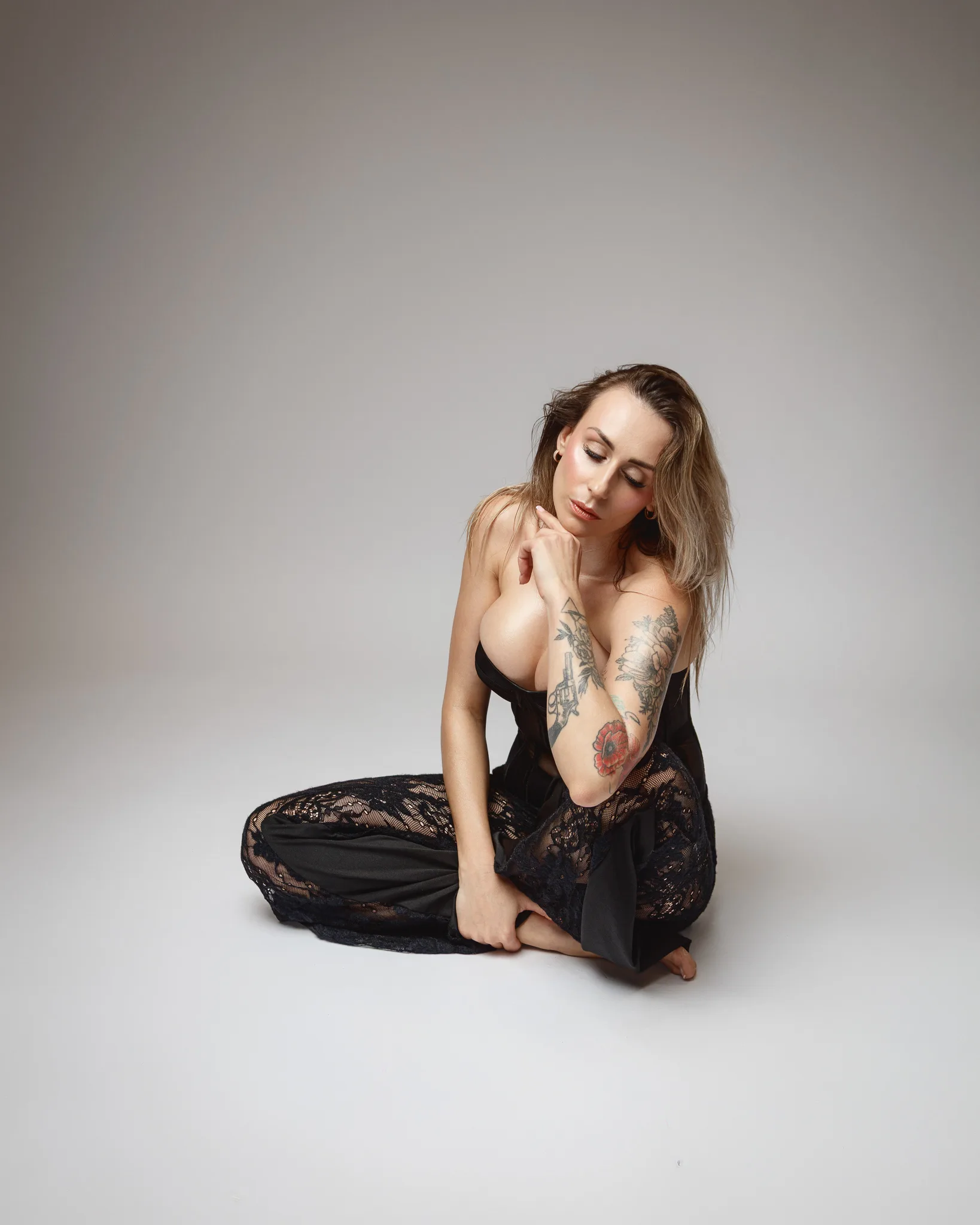 Woman sitting on floor in black outfit.