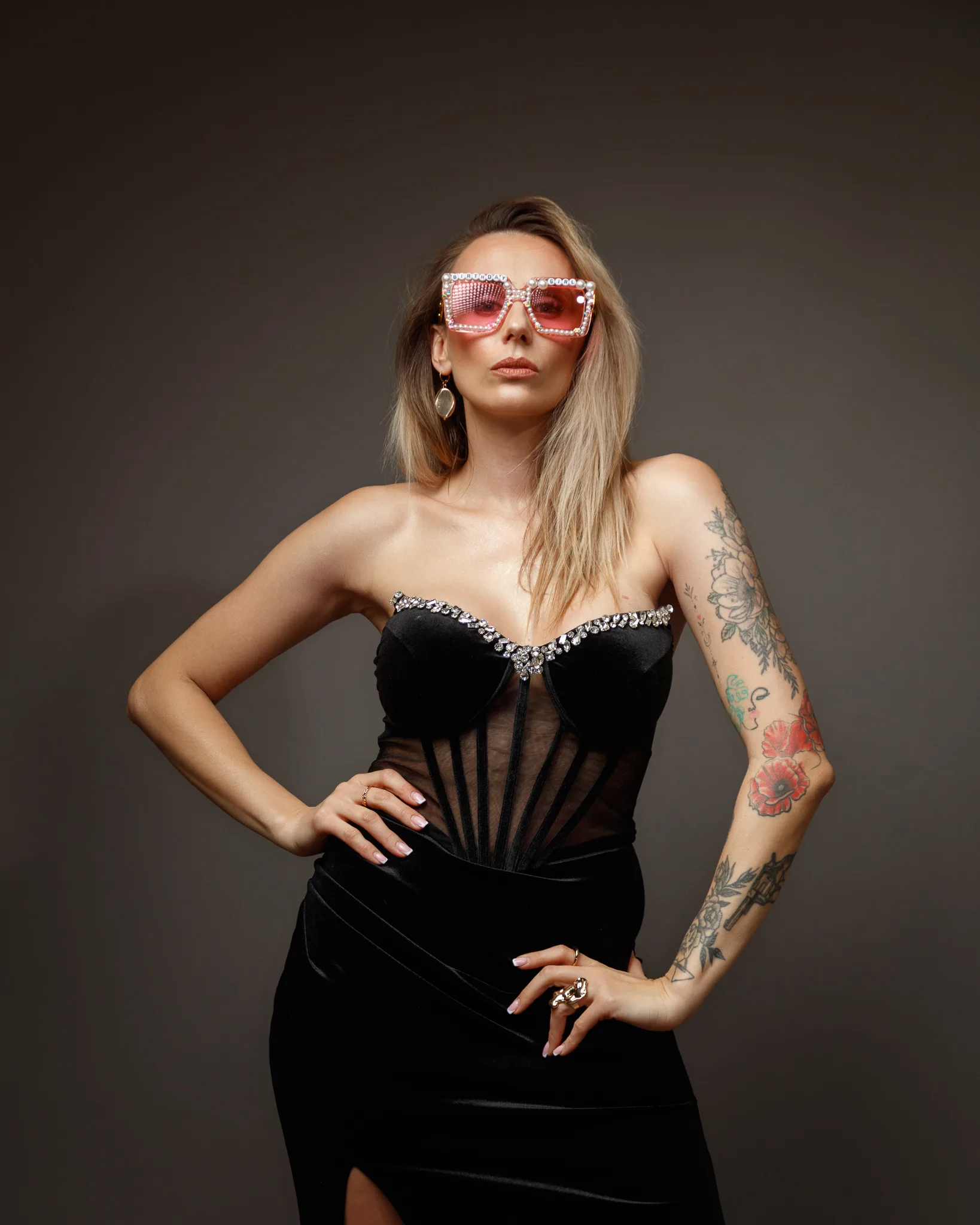 Fashionable woman in black dress and sunglasses.