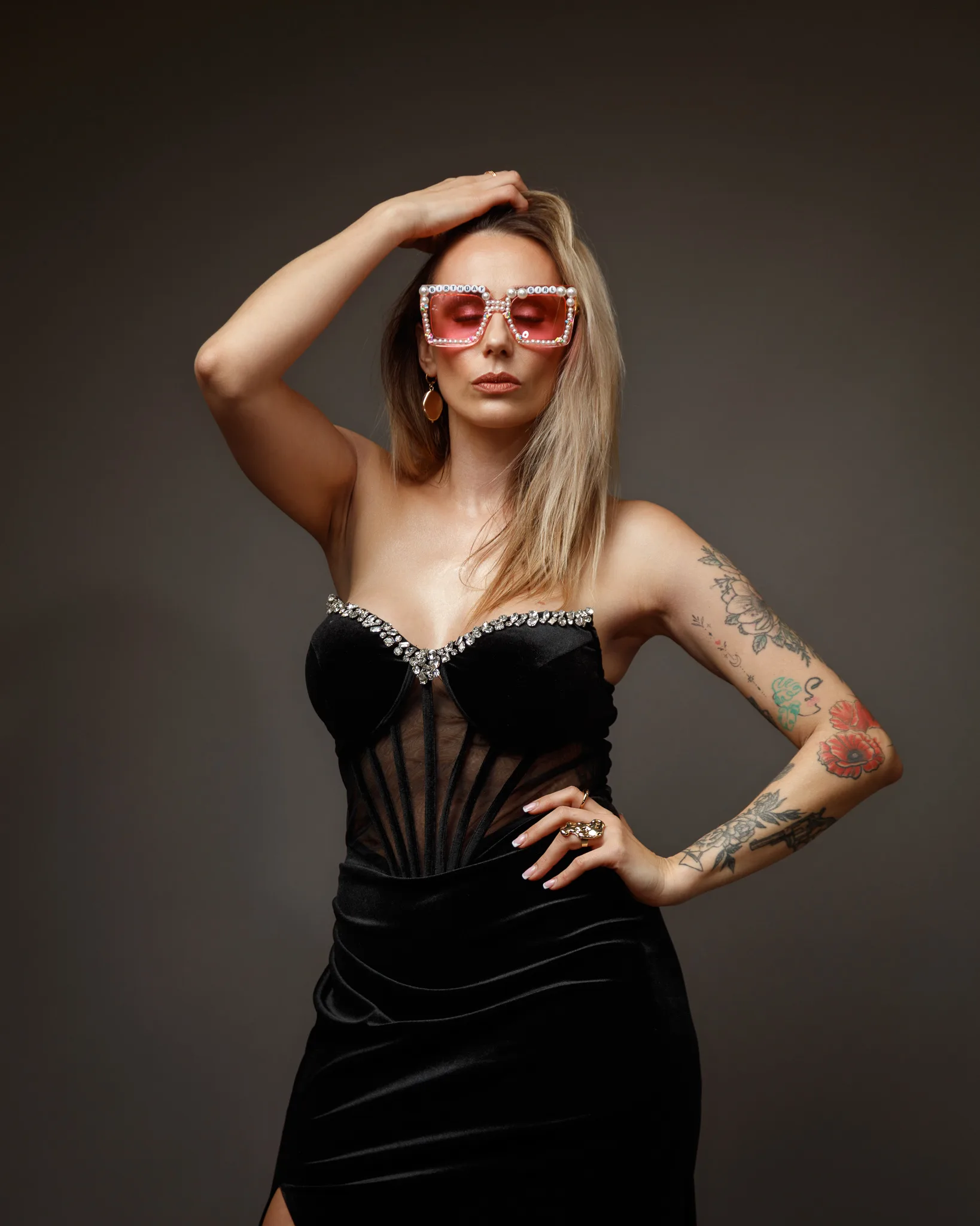 Stylish woman in black dress and sunglasses.