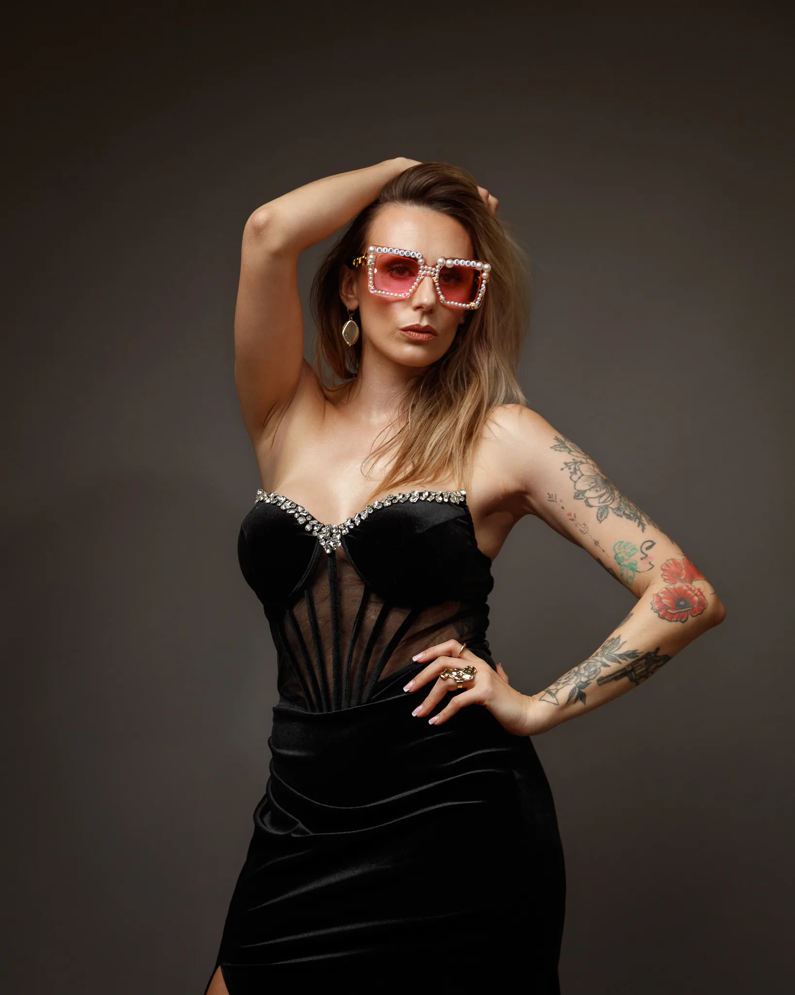 Woman in black dress with tattoos and sunglasses