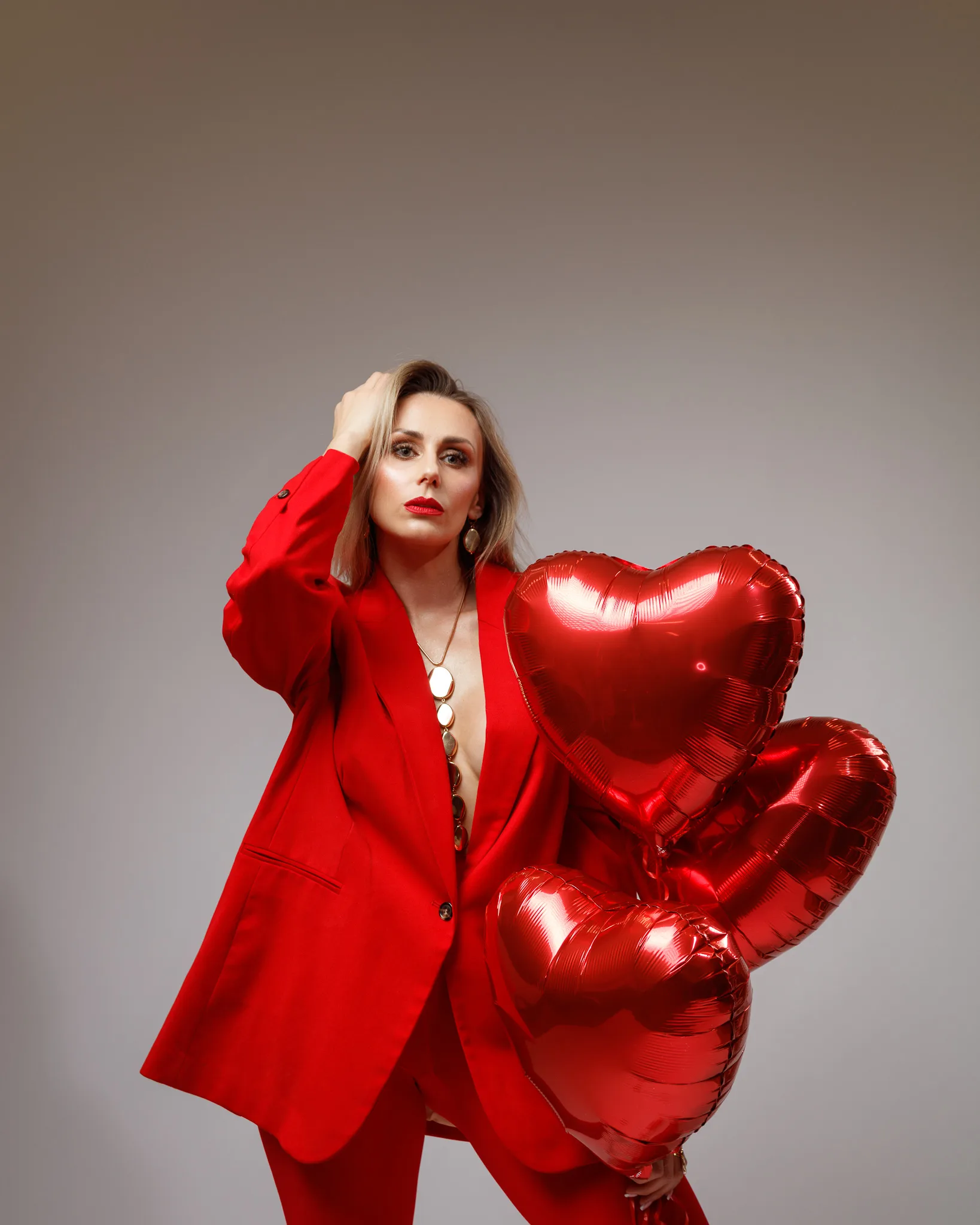 Woman in red suit with heart balloons