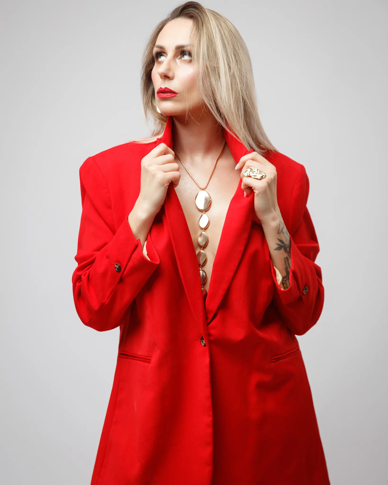 Woman in red blazer with statement necklace.