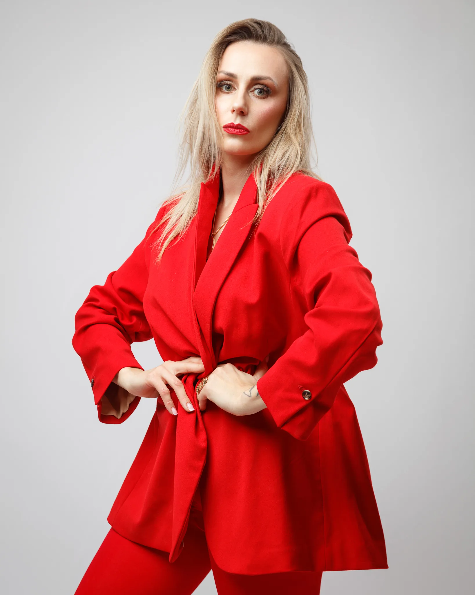 Person in a red suit posing confidently.