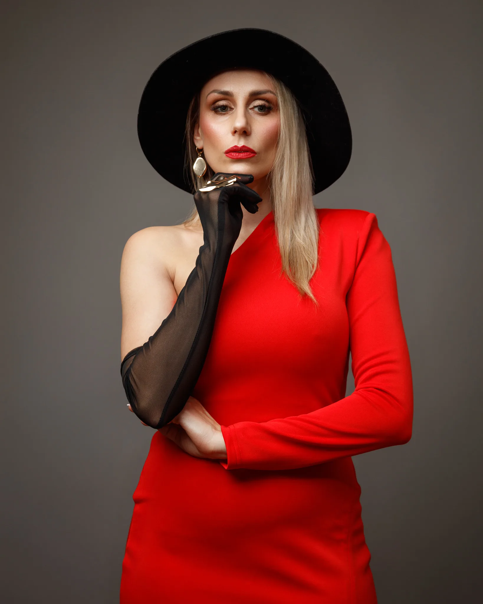 Woman in red dress, black hat and gloves.