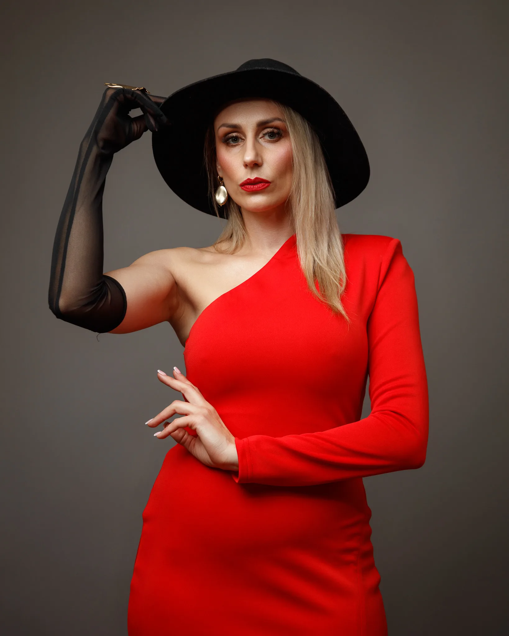 Woman in stylish red dress and black hat.