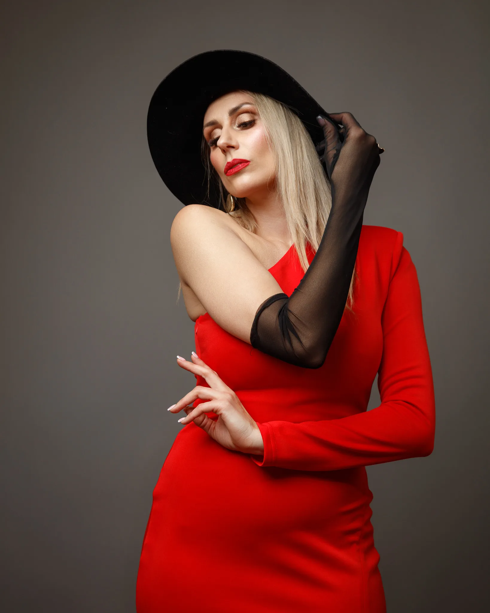 Elegant woman in red dress wearing black hat