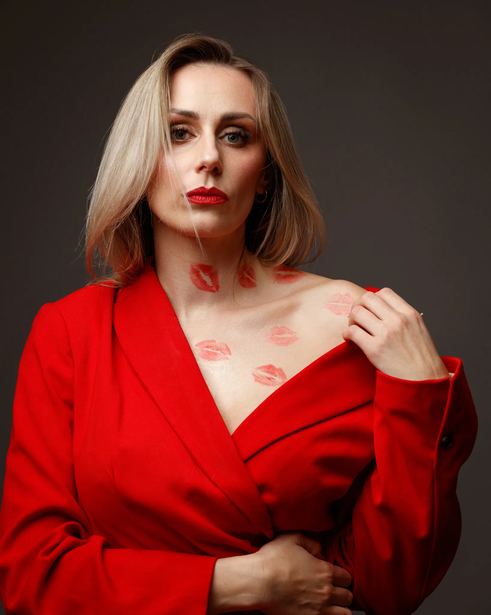 Woman in red coat with lipstick marks on chest.