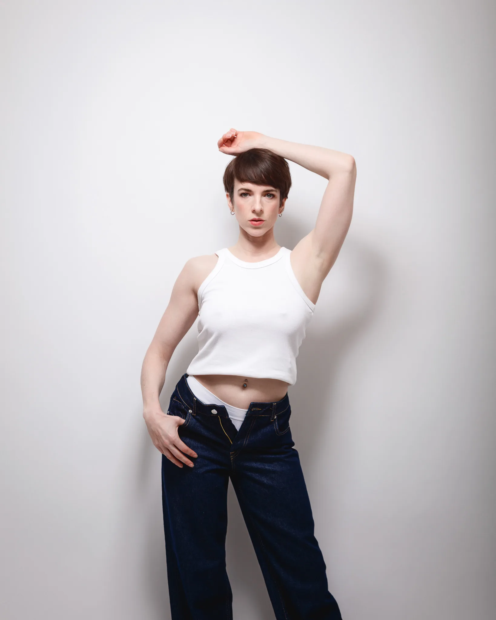 Person posing in white top and jeans.