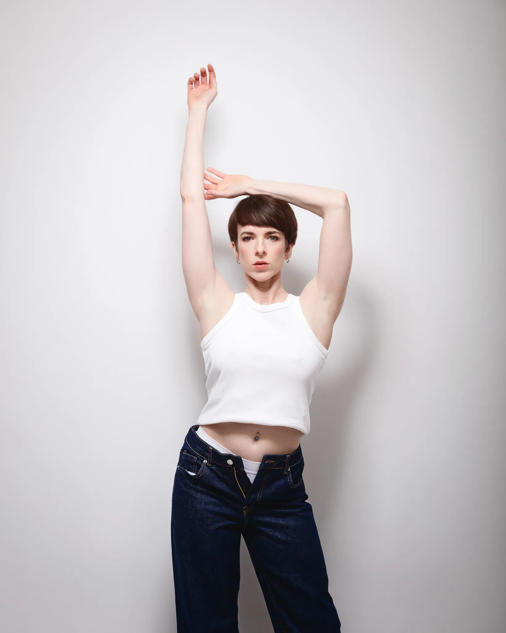 Person posing in white top and jeans.