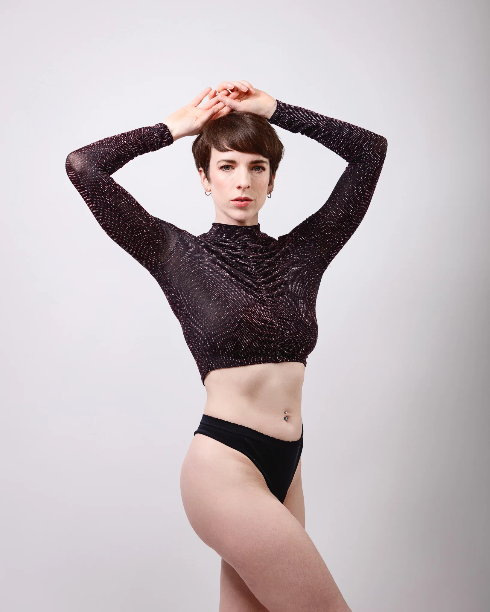 Person posing in sparkly top and black bottoms.