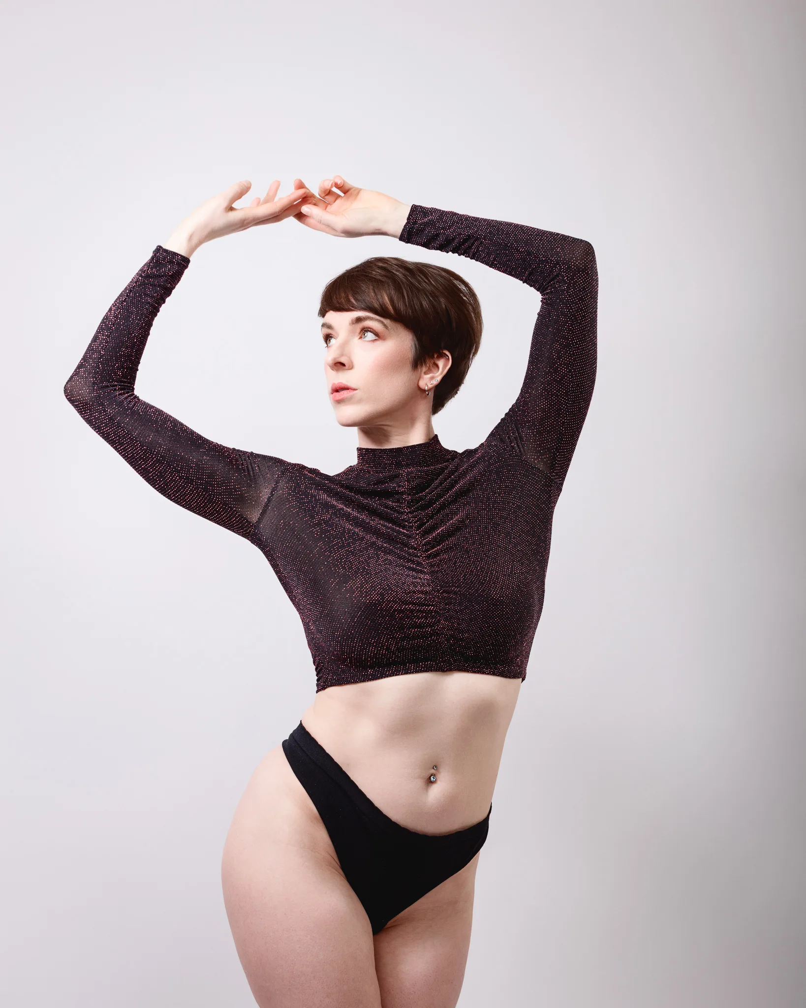 Dancer posing with arms raised gracefully.