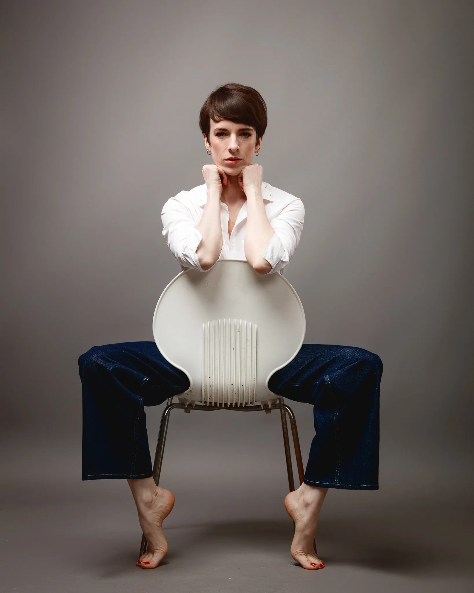 Person seated backwards on a chair, thoughtful pose.