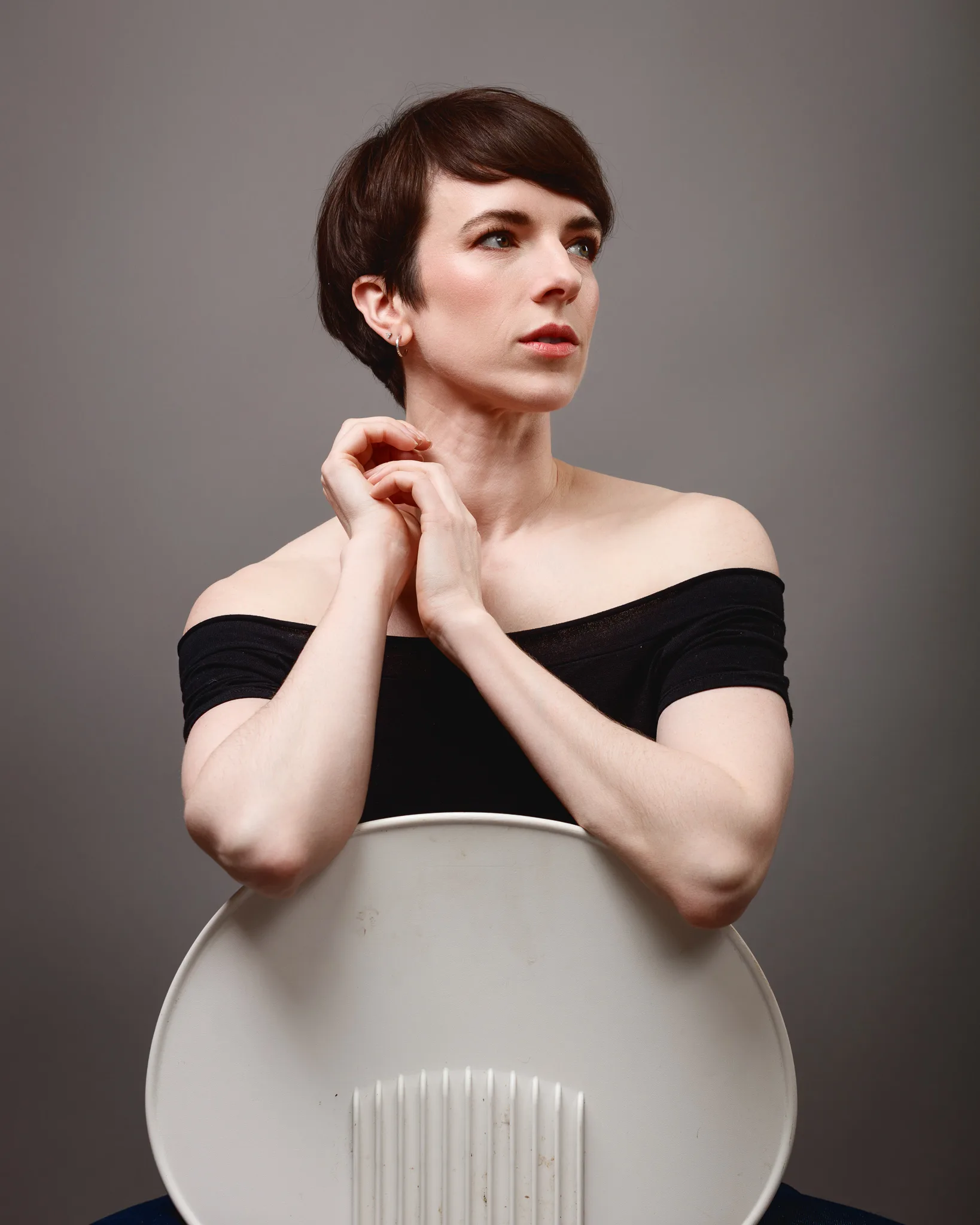Person leaning on chair in studio portrait