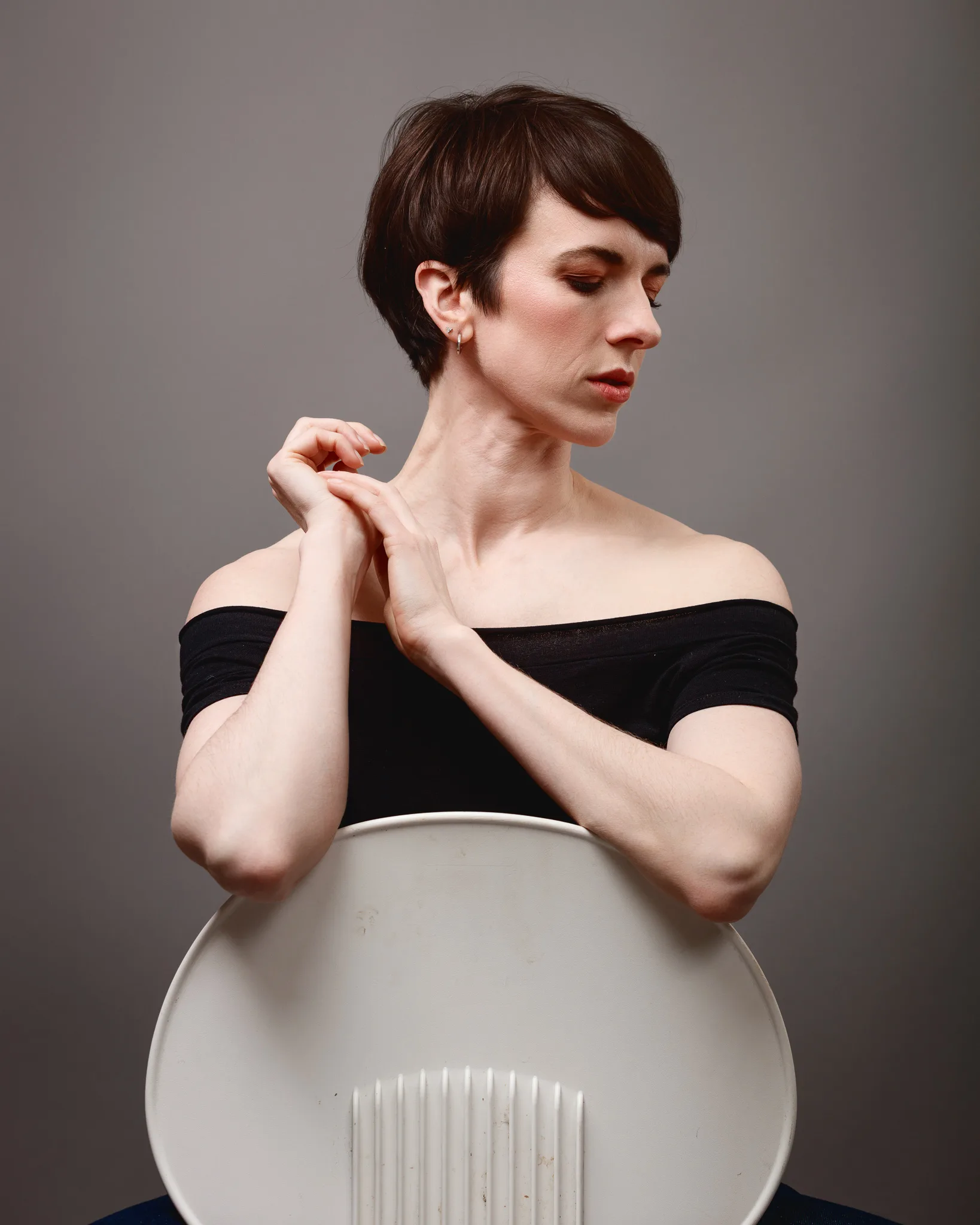 Person in black top, sitting, looking sideways.