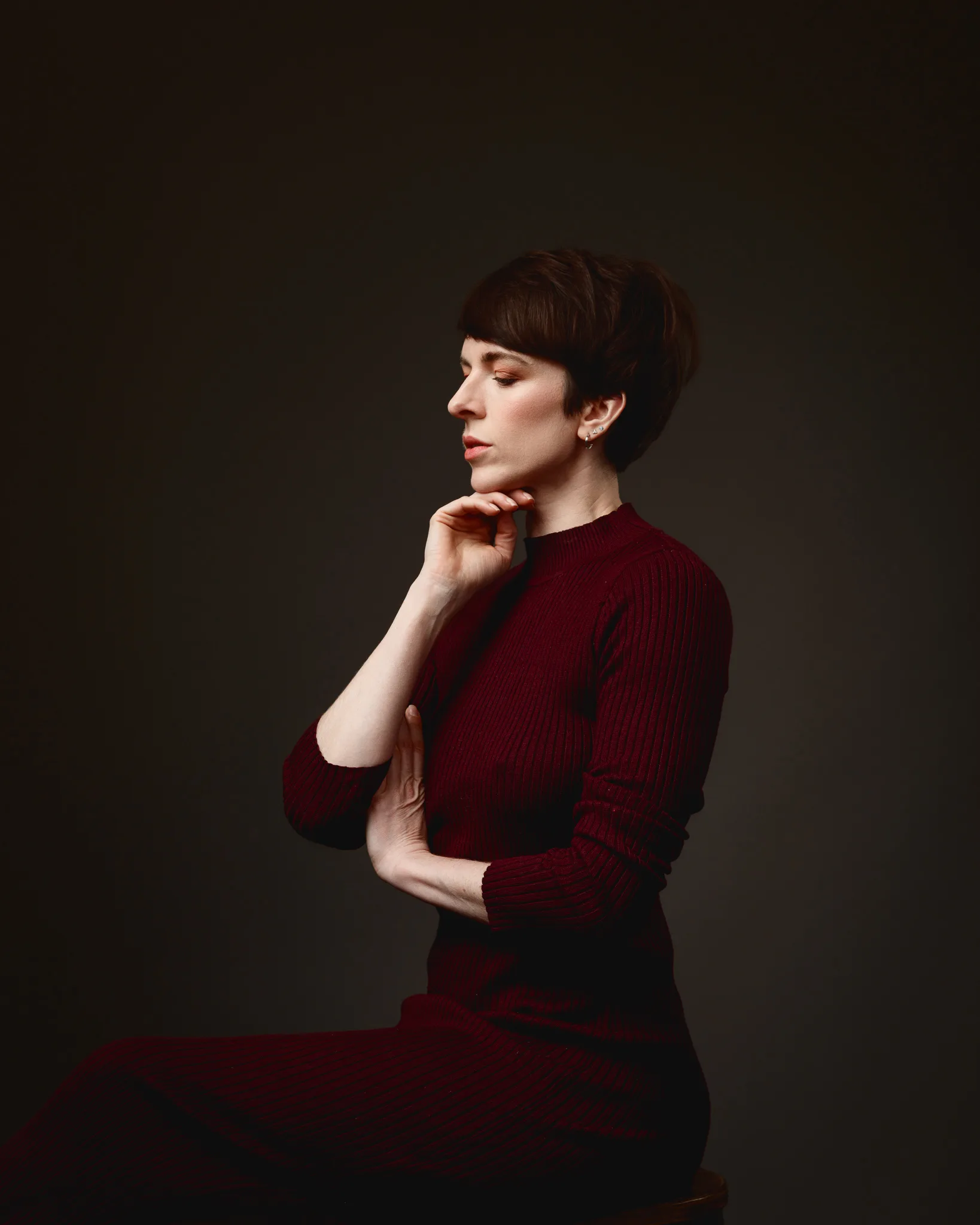 Woman in red dress, pensive pose.