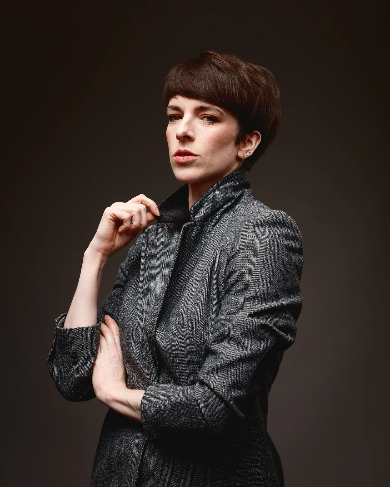 Person in grey jacket posing confidently.