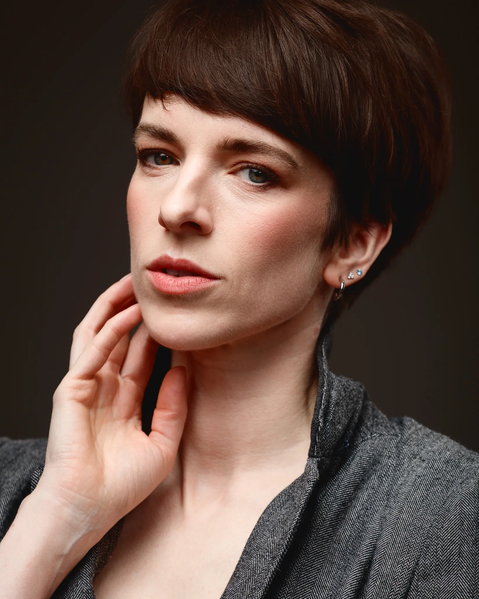 Woman with short hair and thoughtful expression.