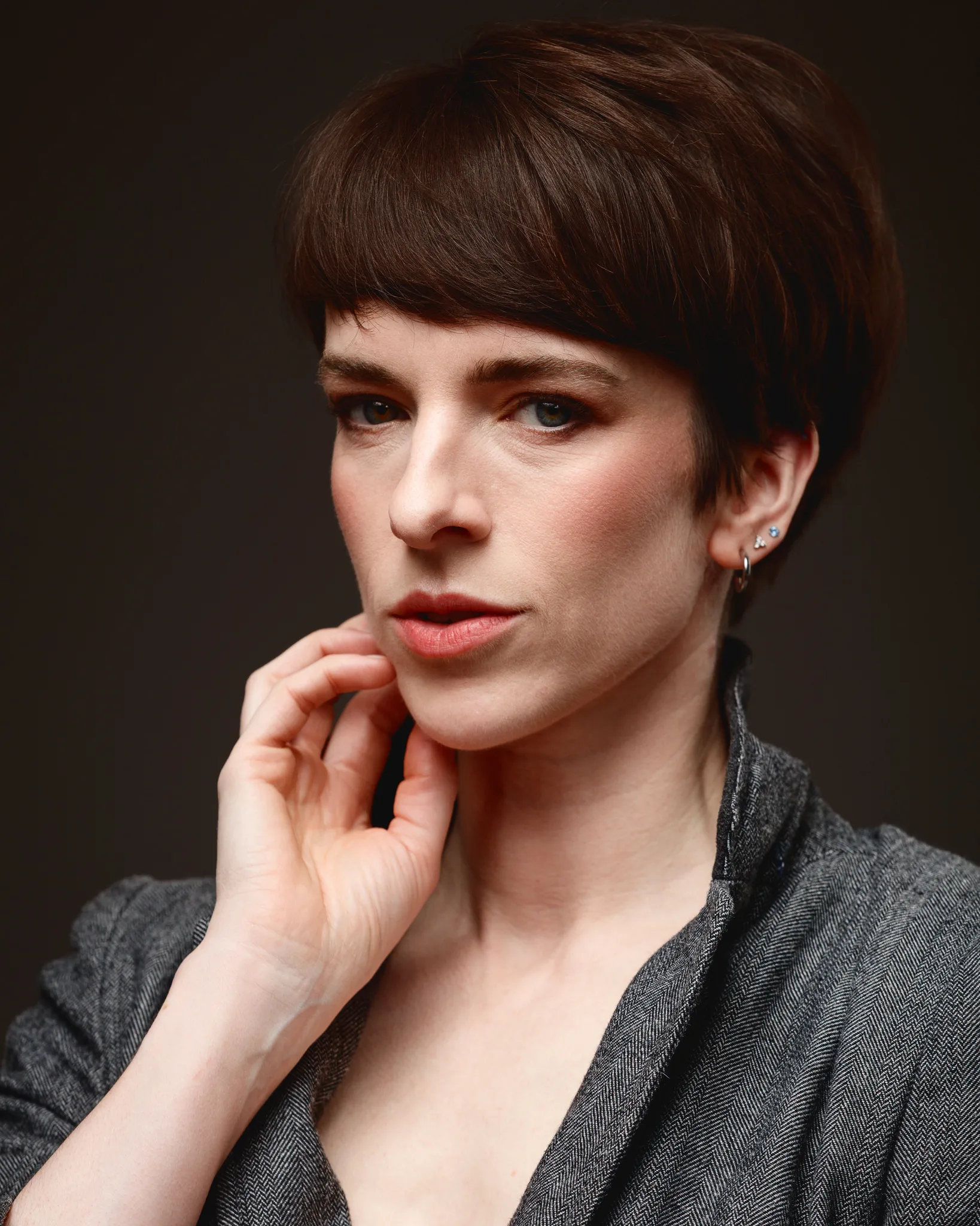 Person with short hair wearing a grey jacket.