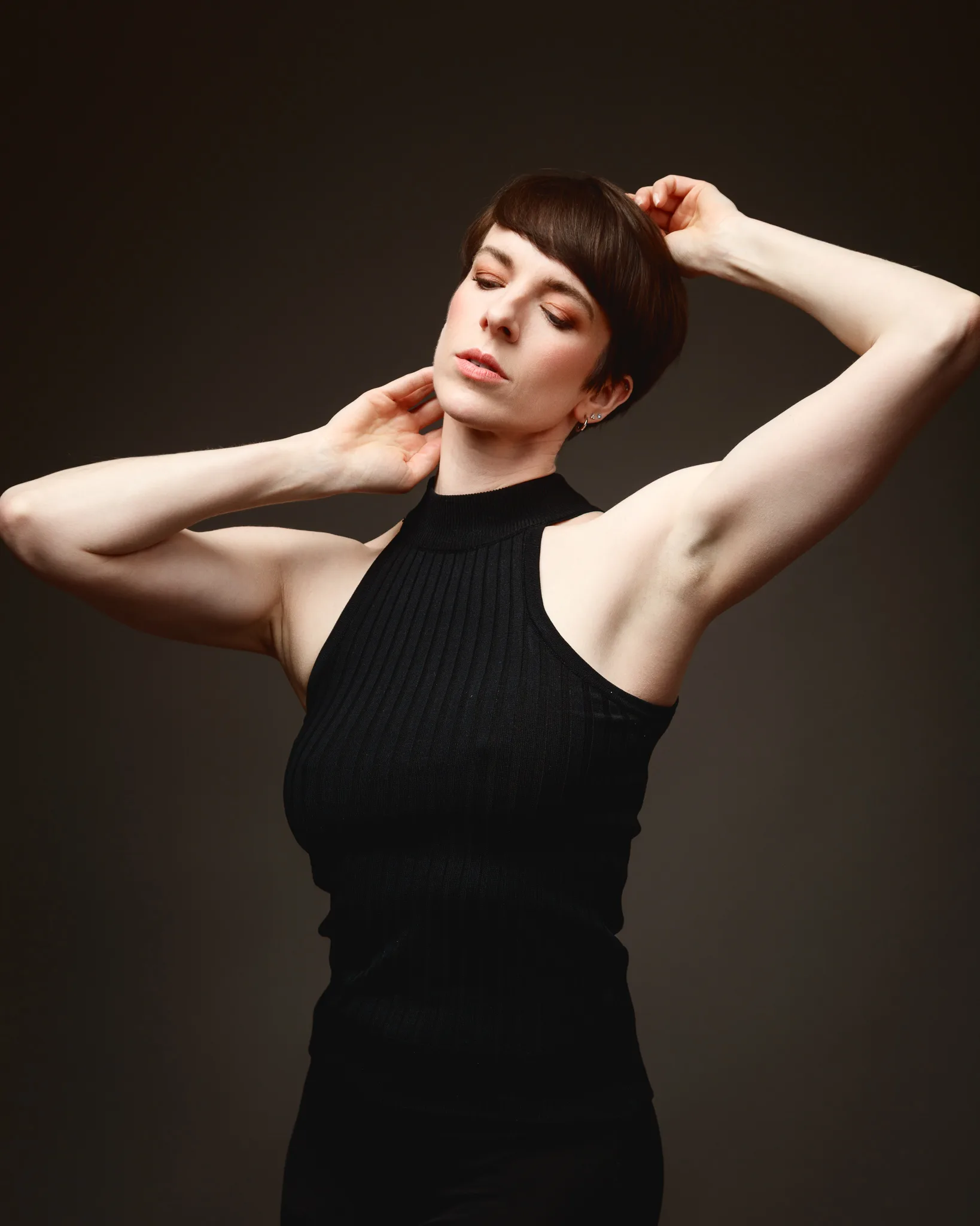 Person posing in sleeveless black top