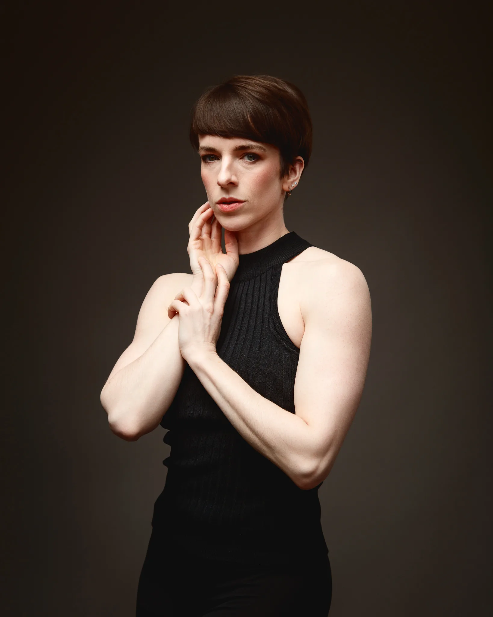 Person in black sleeveless top, thoughtful pose.