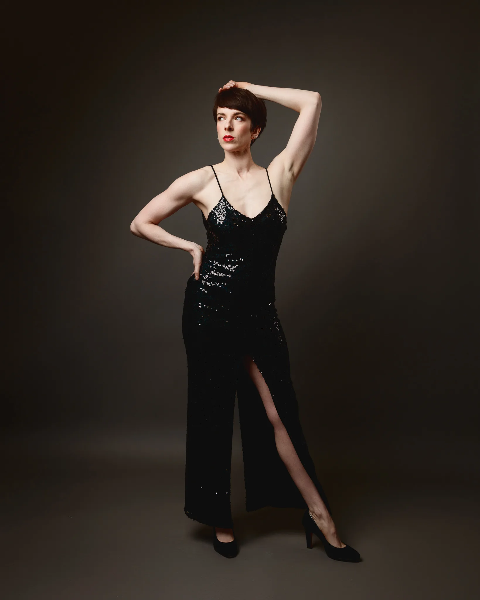 Person in elegant black dress posing stylishly.