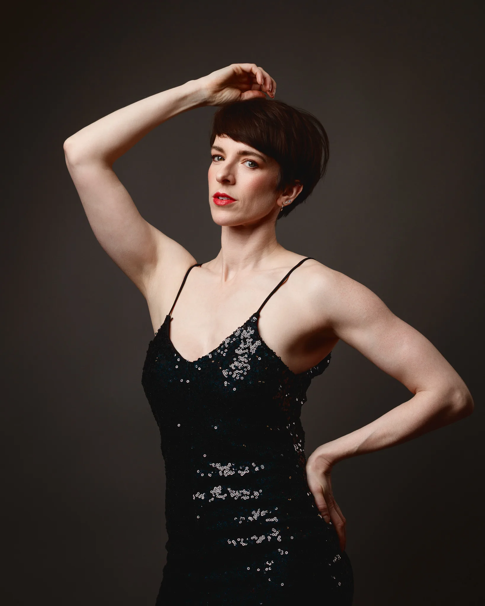 Person in black sequin dress poses confidently.