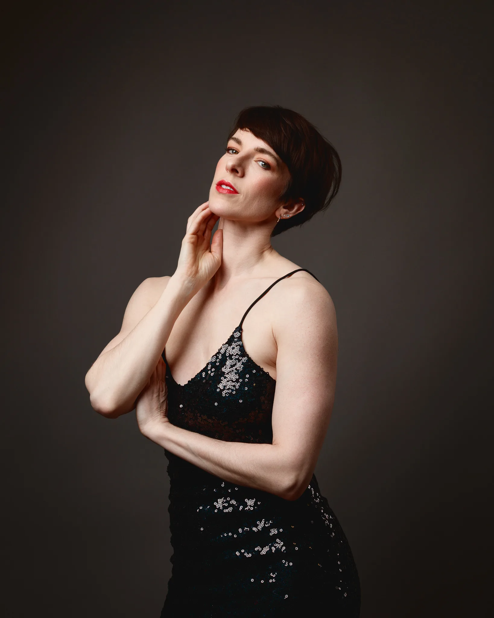 Person in black sequin dress posing gracefully.