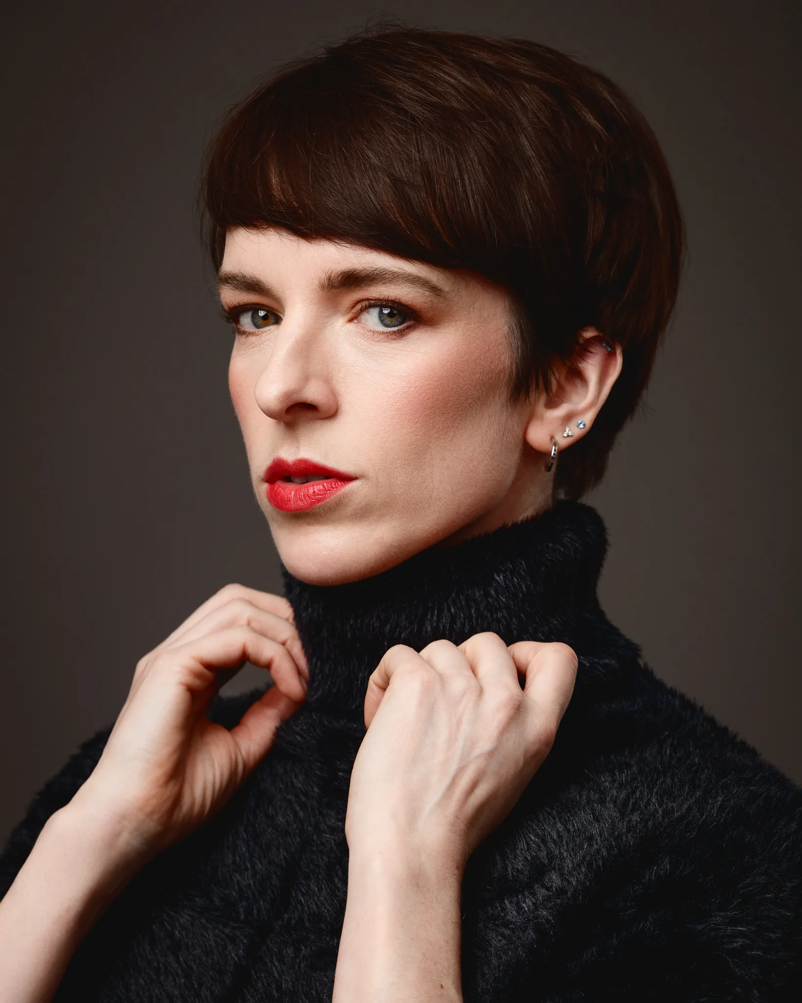 Person wearing black turtleneck, red lipstick, close-up portrait.