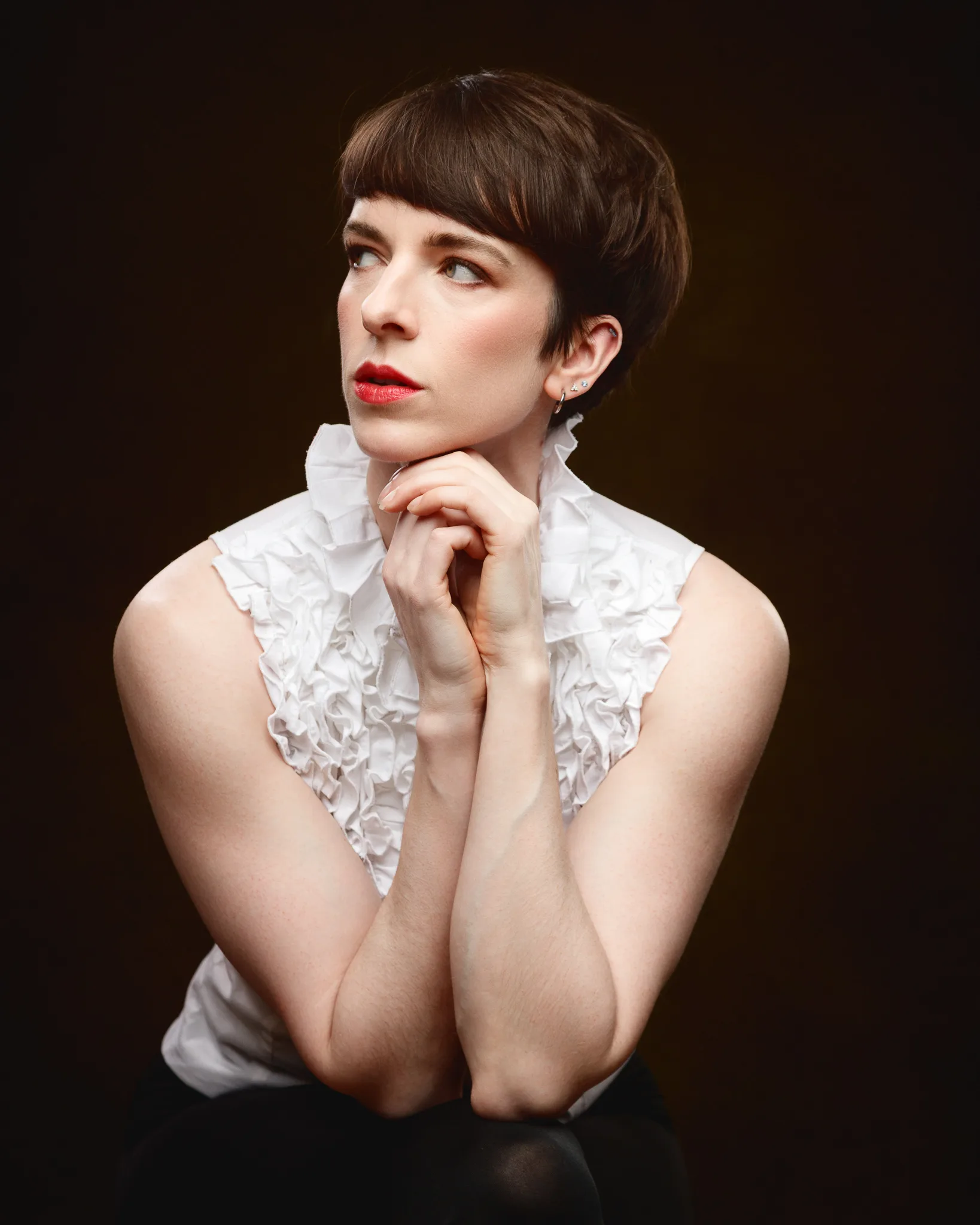 Person in white blouse posing thoughtfully.