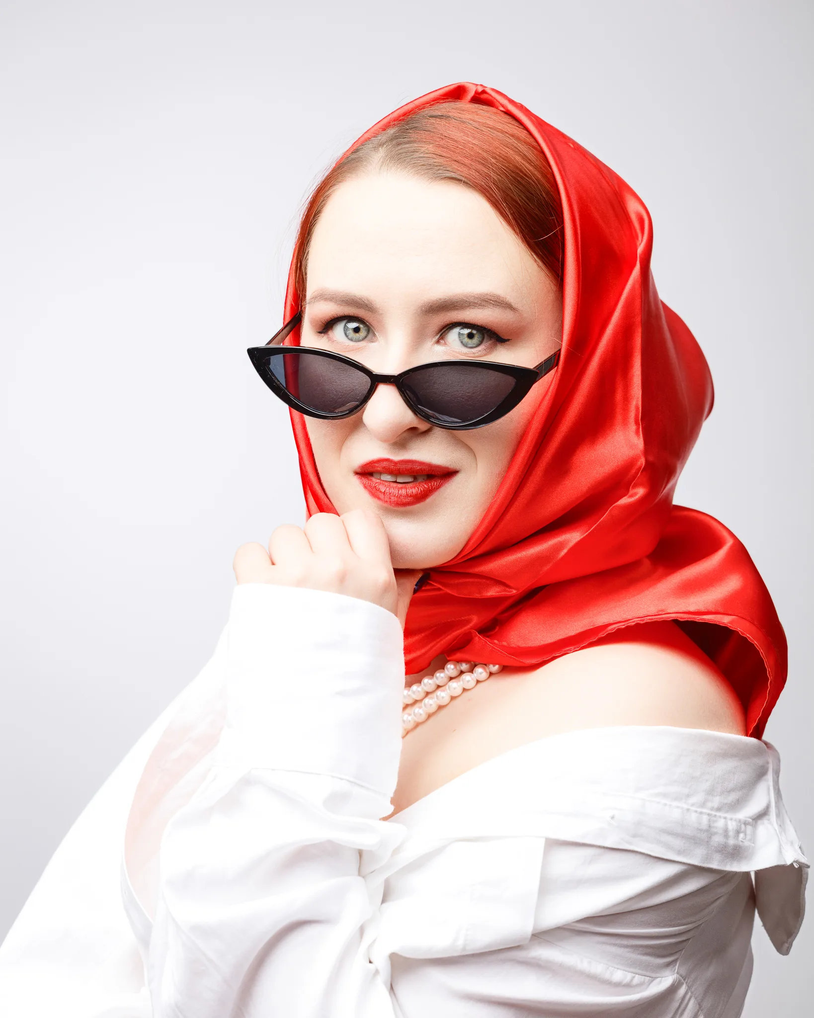 Woman in red scarf and sunglasses, stylish pose.