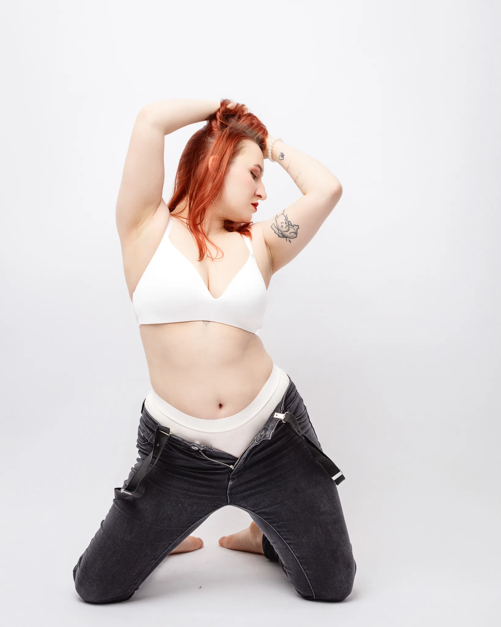 Person kneeling, arms raised, white underwear visible.