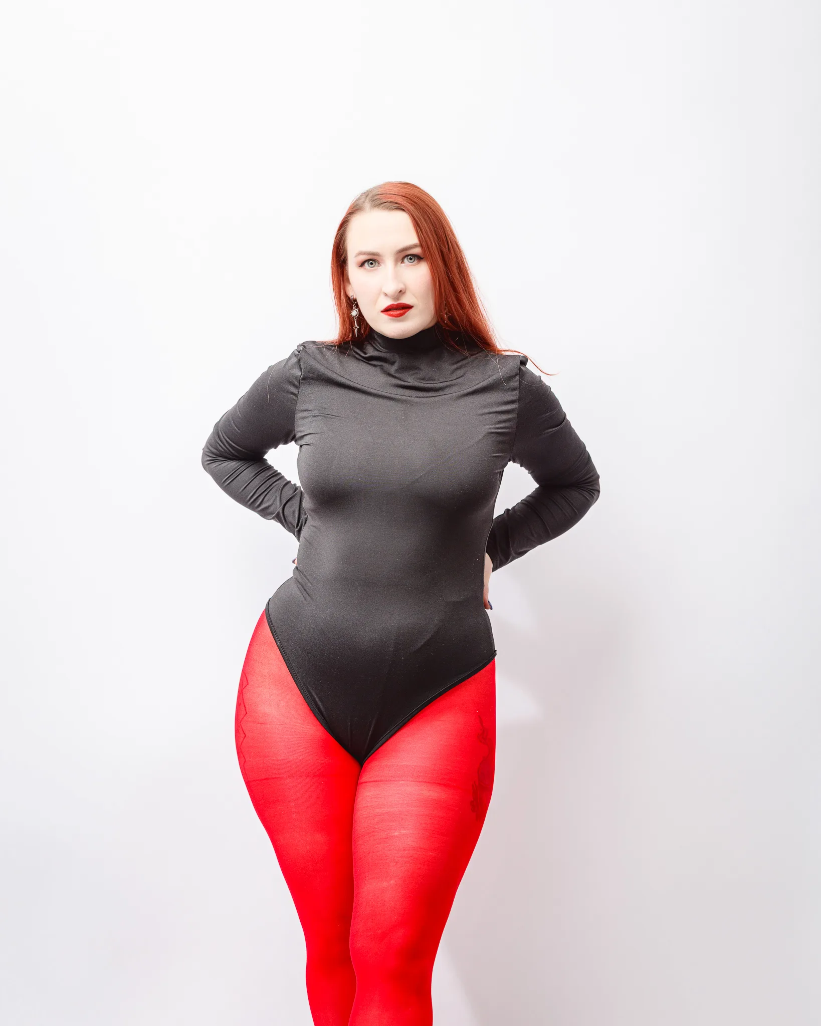 Person in black outfit and red tights posing