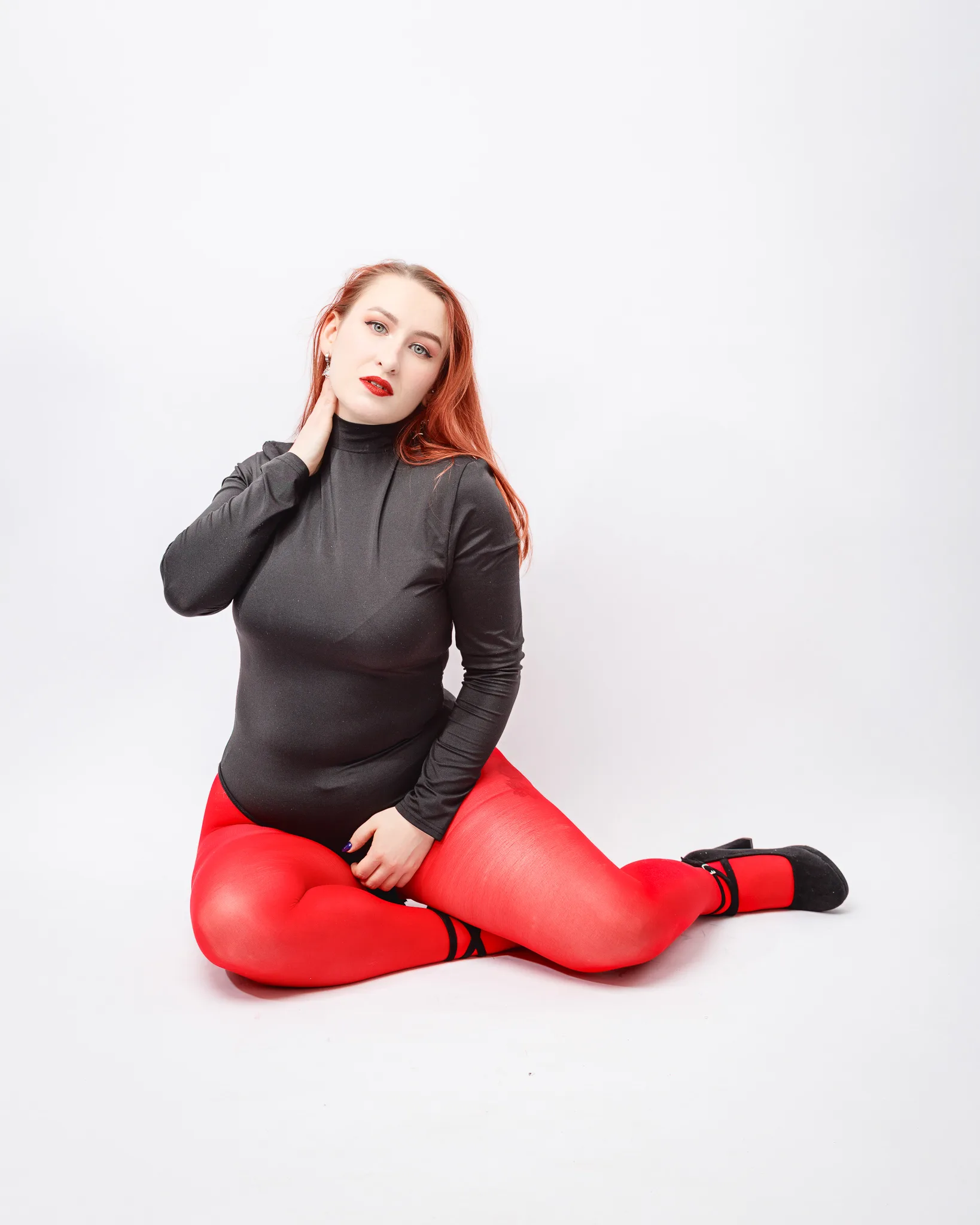 Woman in red tights and black top posing