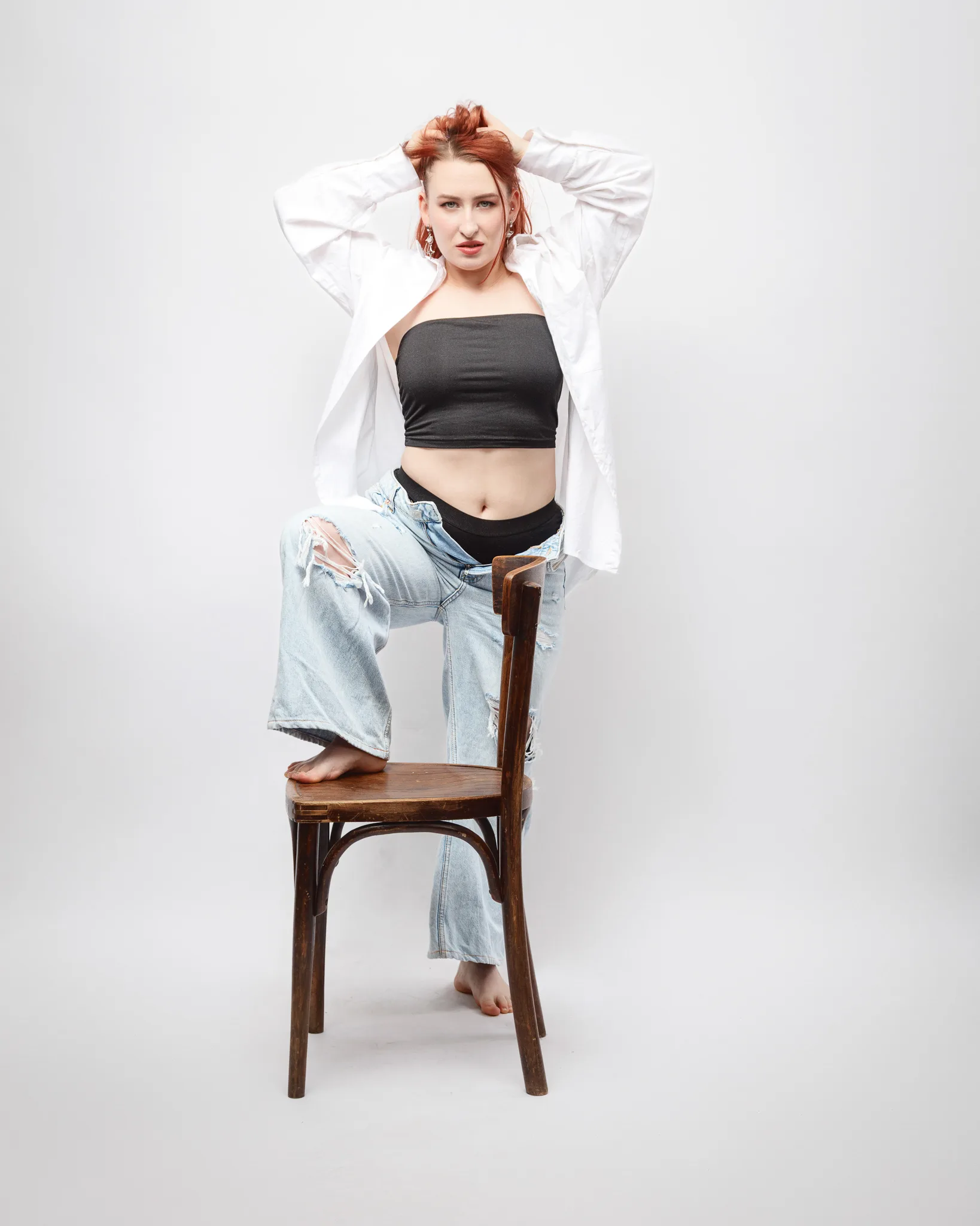 Person posing on chair, casual outfit.
